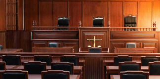 Empty courtroom with wooden benches and judges bench.