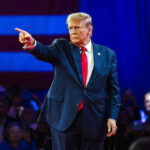 Surprise Launch – Trump’s NEW App Goes Live! Person in suit pointing during a public event.