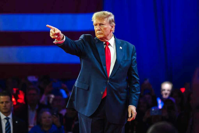 2430065795 Person in suit pointing during a public event.