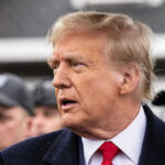 Trump Family Hit With Devastating Cancer Diagnosis! Man in suit and red tie speaking outside.