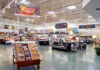 Supermarkets SECRETLY Spying On While You Shop! Supermarket interior with various food sections and displays.