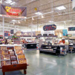 Supermarkets SECRETLY Spying On While You Shop! Supermarket interior with various food sections and displays.