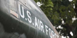 FBI Issue Reward After Top Airman Betrays US! U.S. Air Force plane with trees in background.