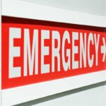 E-Coli Breaks Out Across Beloved Chain – Child Hospitalized! Emergency sign indicating direction with a red background and white text