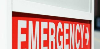 E-Coli Breaks Out Across Beloved Chain – Child Hospitalized! Emergency sign indicating direction with a red background and white text