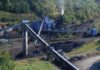 Industrial coal processing facility with conveyor belts and smoke stack