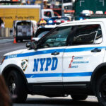 Police Cruiser Mows Jogger During Emergency Call NYPD police car on a city street scene.