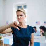 ICE Agents SPYING on Citizens Social Accounts Woman with thumbs down in voting location.