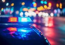 Cop ARRESTED – Badge Turned Predator! Police car with flashing lights at night.