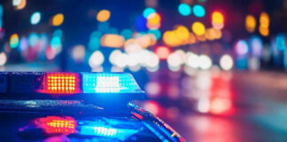 Cop ARRESTED – Badge Turned Predator! Police car with flashing lights at night.