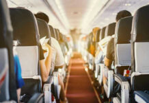 Passengers seated inside an airplane cabin.