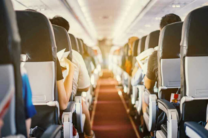 626651186 Passengers seated inside an airplane cabin.