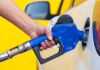 Gas Price SKYROCKETS Amid 250th Celebrations! A person refueling a car at a gas station with a blue nozzle