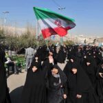 Iran Expedites Executions of Political Prisoners Amid Trump Talks Group of women in black attire marching with an Iranian flag