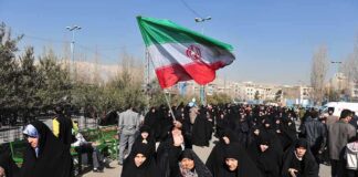 Iran Expedites Executions of Political Prisoners Amid Trump Talks Group of women in black attire marching with an Iranian flag
