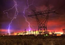 Midwest Blackout Triggers Airport Chaos Lightning strikes illuminate a power station against a colorful sunset sky