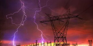 Midwest Blackout Triggers Airport Chaos Lightning strikes illuminate a power station against a colorful sunset sky