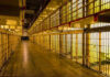 25 DEAD, 100 Injured in Prison CHAOS! Empty hallway between rows of prison cells.