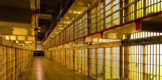 25 DEAD, 100 Injured in Prison CHAOS! Empty hallway between rows of prison cells.