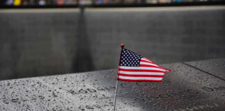 9/11 Families Revolt – Order Muslim Mayor to STAY AWAY! American flag on a rainy memorial nameplate.