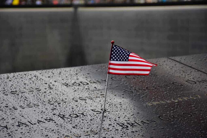 American flag on a rainy memorial nameplate.