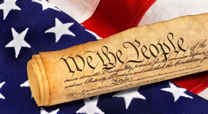 shutterstock_1033952626 Rolled U.S. Constitution on an American flag