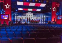 Dem Senate Debate Labeled A Disaster – Can’t Answer SINGLE Question Debate stage with red and blue lighting and empty audience seats