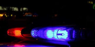SICKO On The Loose After Forced Daylight Rape! Close-up of police lights flashing in blue and red at night