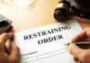 GOP Rep’s Wife Files Restraining Order After Disturbing Allegations Restraining order form on a desk with hands holding a pen