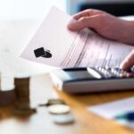 Migrants Granted College Admission Priority Over U.S Students! Hands calculating student loan with document and calculator