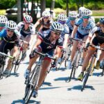 Cyclists racing in a tight pack on a road