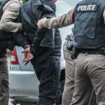 Illegal Alien Attacks Cop, Tries to Steal His Gun Police officers arresting a person beside a car