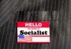 Socialist Boss Living With PARENTS in Million-Dollar Townhouse Name tag on a pinstripe suit jacket pocket