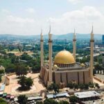 Islamic Prayer BLASTS Five Times Per Day Across U.S Cities Golden-domed mosque with four minarets in a modern cityscape