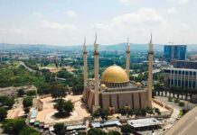 Islamic Prayer BLASTS Five Times Per Day Across U.S Cities Golden-domed mosque with four minarets in a modern cityscape
