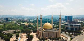 Islamic Prayer BLASTS Five Times Per Day Across U.S Cities Golden-domed mosque with four minarets in a modern cityscape