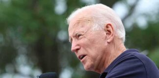 Biden Aide VANISHES After Endorsing Republican elderly man speaking into a microphone outdoors