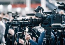 Times Square Showdown: Kirk Statue Sparks Fury Broadcast cameras on tripods at a press event