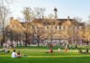 Frat House Horror Rocks University Students relaxing on a campus quad in front of a brick academic building