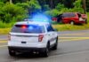 Dem Candidate ARRESTED – Handcuffed in Squad Car Police SUV with flashing lights at roadside crash scene