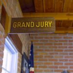 Grand jury sign in a brick-walled hallway