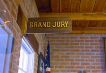 Grand jury sign in a brick-walled hallway