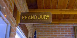 Clancy Juror TARGETED For Being Republican Grand jury sign in a brick-walled hallway