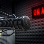 Radio Stations REMOVE Artist Over Gaza Controversy Close-up of a studio microphone with an illuminated on-air sign