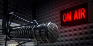Close-up of a studio microphone with an illuminated on-air sign
