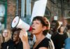 Far Left Surges – Muslim Voters Demand Socialism Woman with megaphone leading a protest