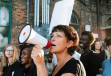 Far Left Surges – Muslim Voters Demand Socialism Woman with megaphone leading a protest