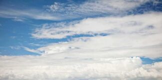 White passenger boat cruising on open sea under cloudy sky