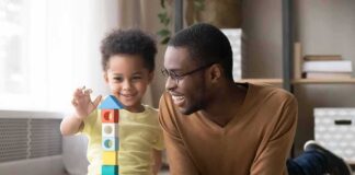 Airlines Providing a Huge Benefit to Flyers With Trump Accounts Father and child building a tall tower with colorful wooden blocks on the floor