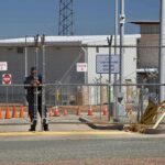 Air Base Breach Sparks Violent Clash Security guard at chain-link gate of fenced facility